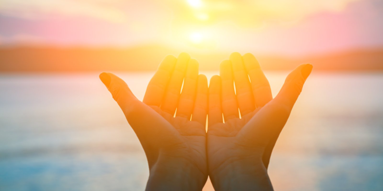 open hands at sunset